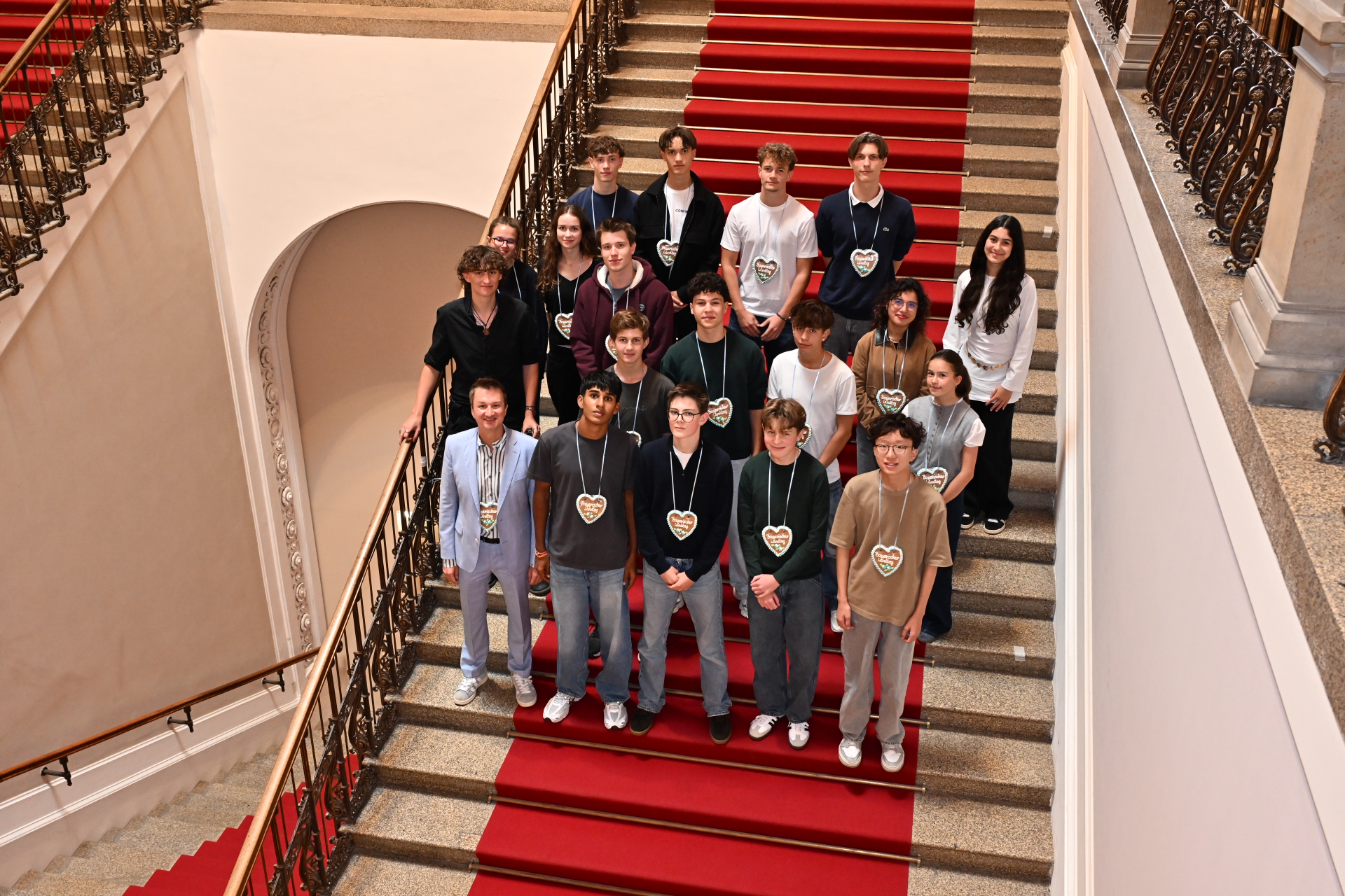 Ein Gruppenfoto auf den Stufen vor dem Plenarsaal des Bayerischen Landtags ist zu sehen bei dem Projekt „(D)eine Minute für die Demokratie".