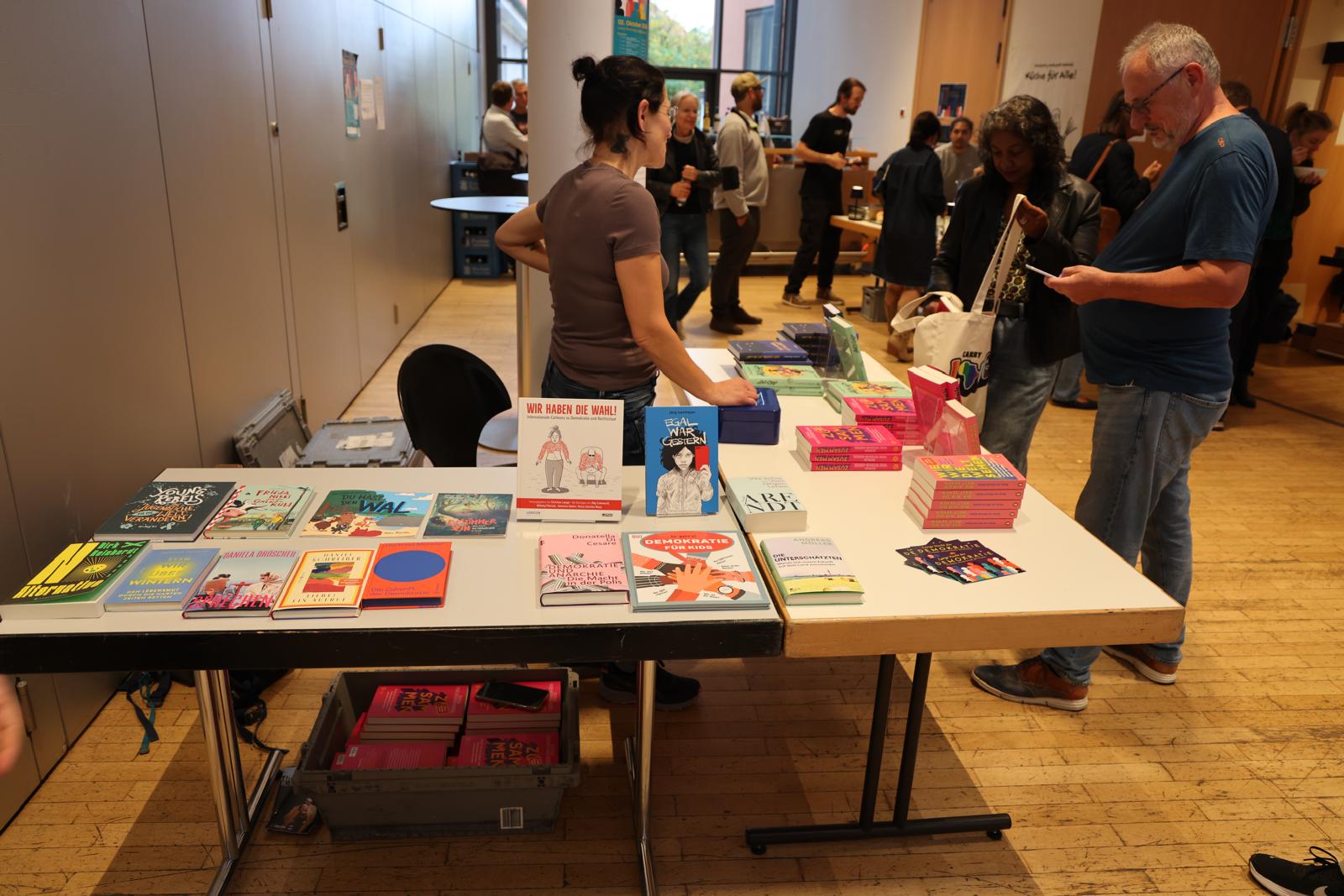 Ein Stand mit Büchern wird von interessierten Besucherinnen und Besuchern auf der Langen Nacht der Demokratie angeschaut.